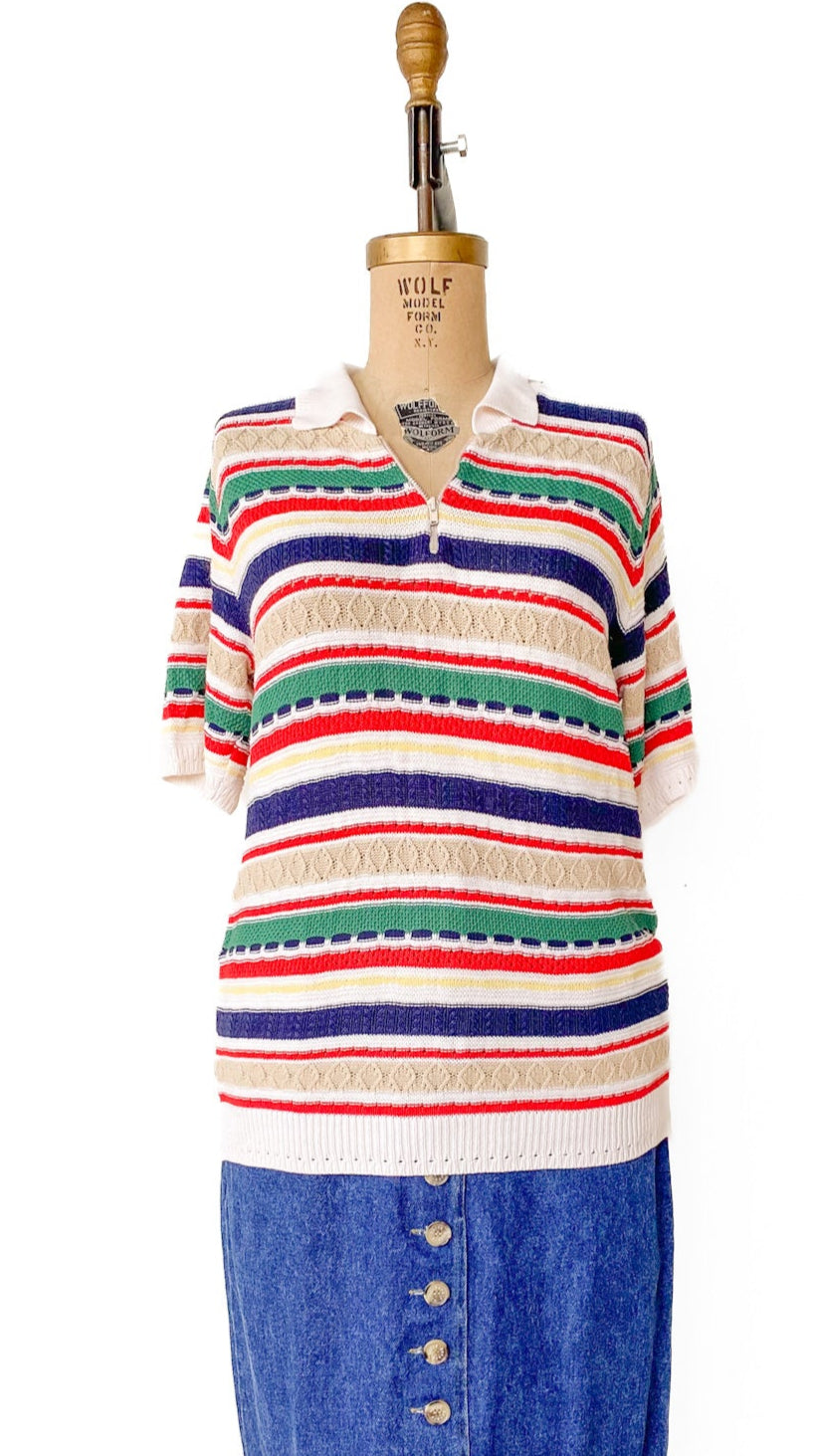 Mannequin wearing a colorful striped sweater and blue denim skirt on a white background