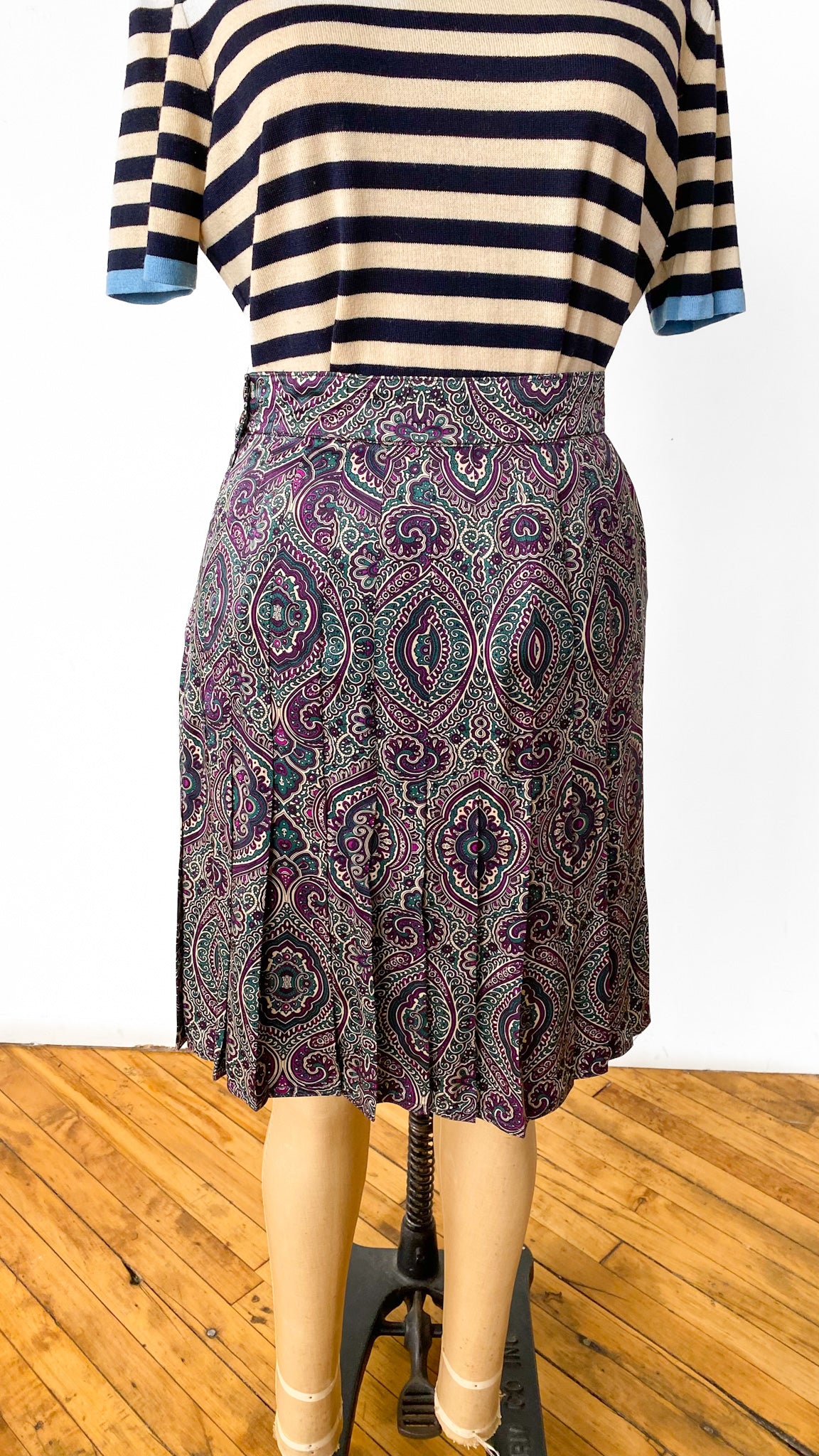 Striped shirt and patterned skirt on a mannequin against a white background