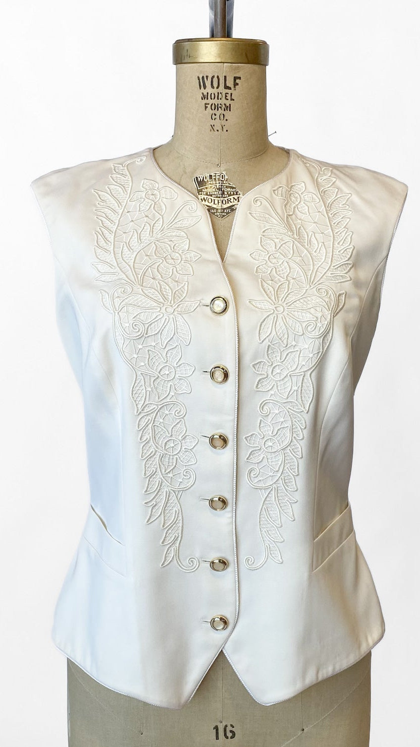 White embroidered waistcoat on a mannequin against a white background