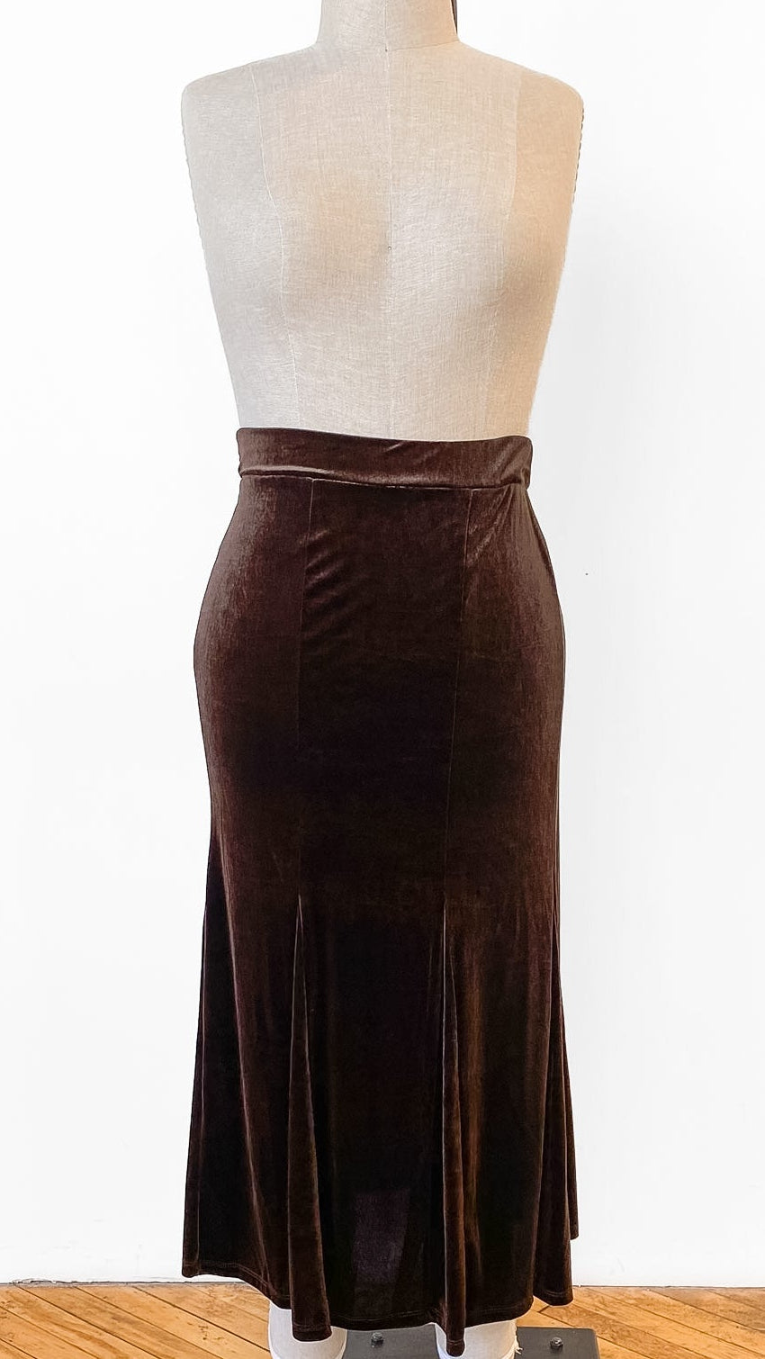 Brown velvet skirt on a mannequin against a white background