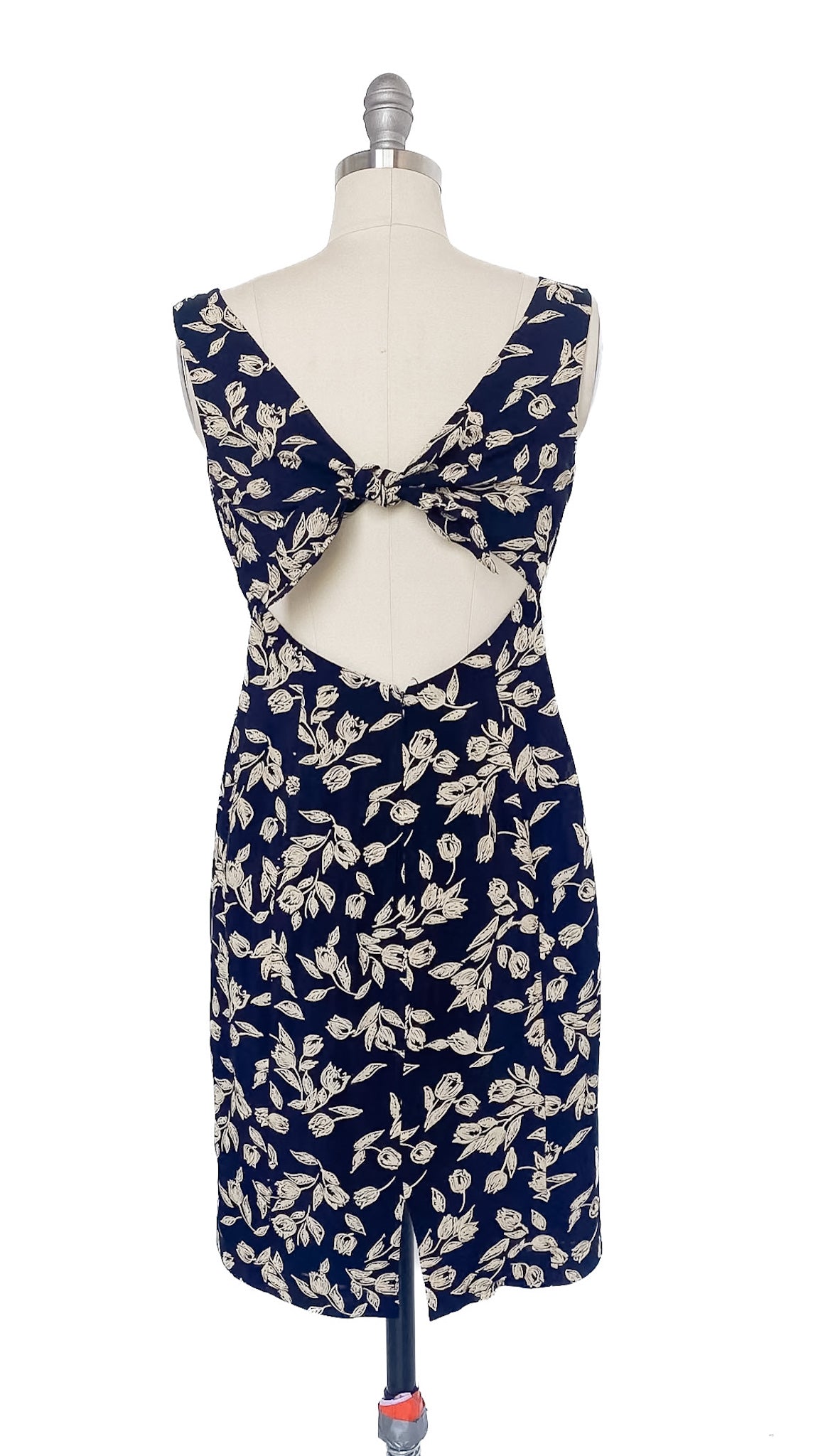 Navy blue dress with floral pattern on a mannequin against a white background
