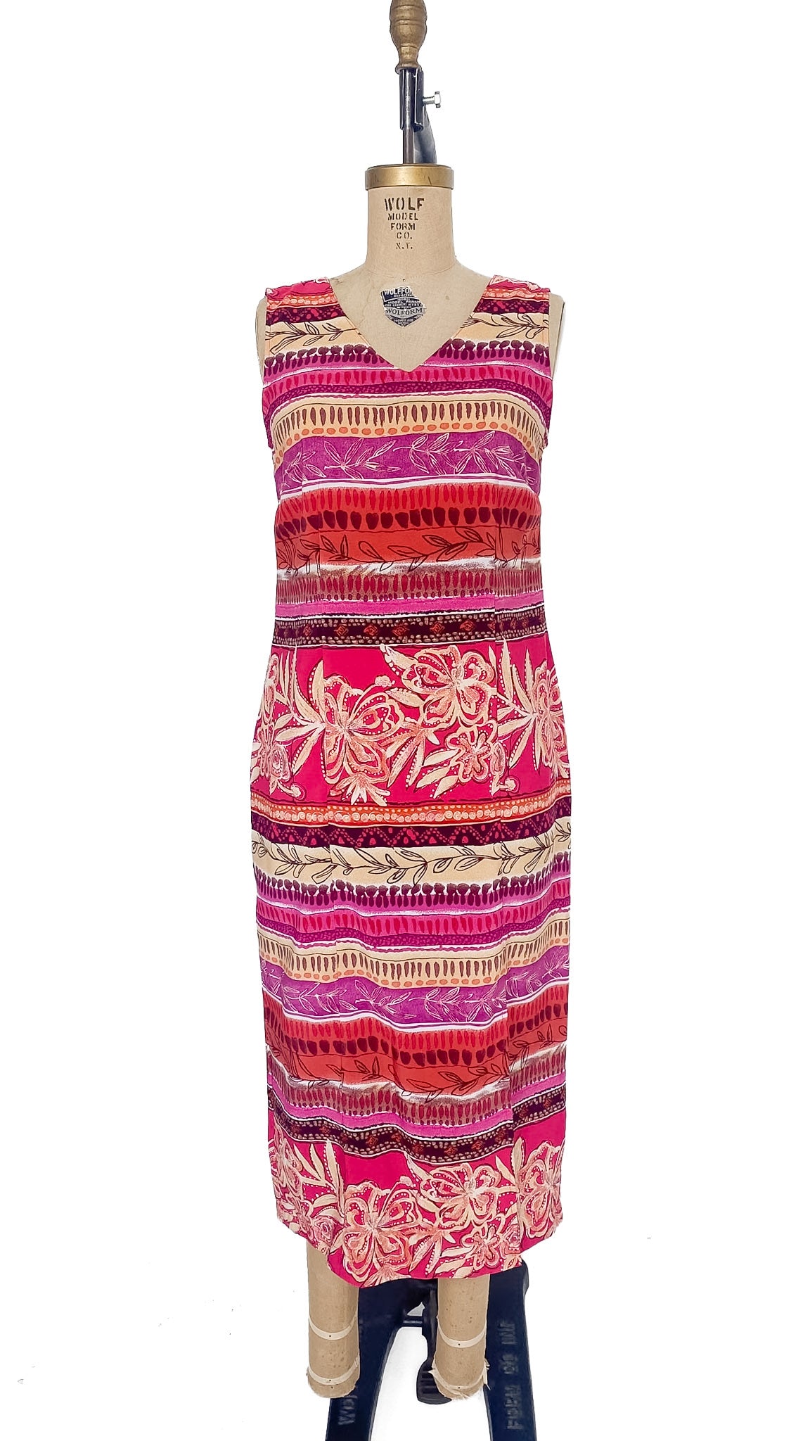 Colorful patterned dress on a mannequin against a white background