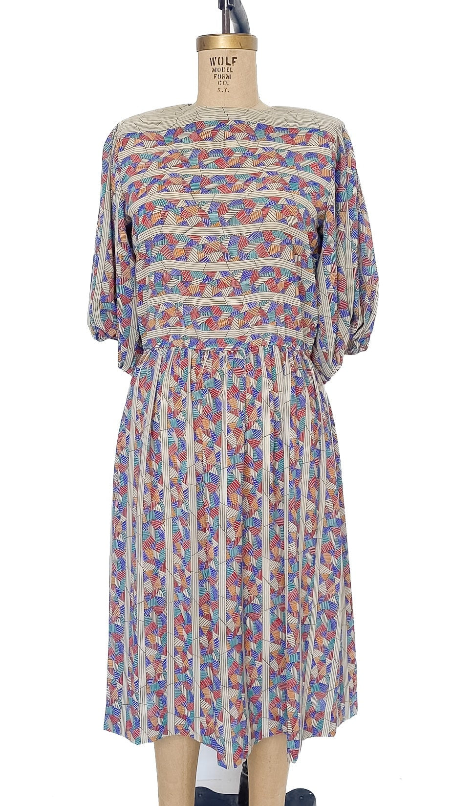 Multicolored patterned dress on a mannequin against a white background