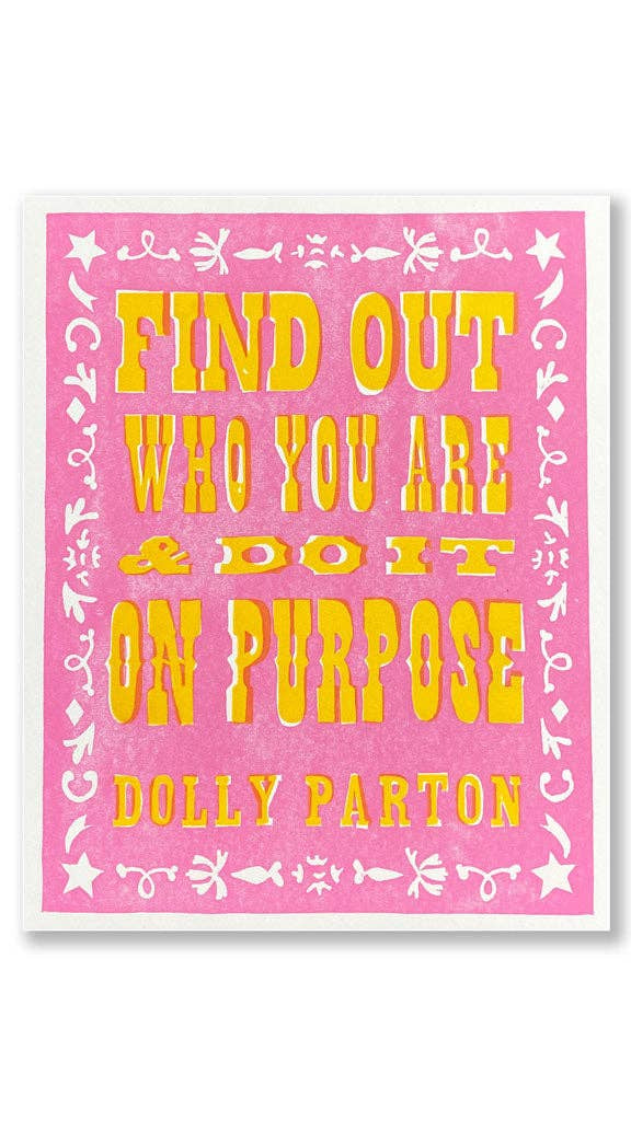 A square art print featuring a pink background with yellow text that reads 'FIND OUT WHO YOU ARE & DO IT ON PURPOSE' and 'DOLLY PARTON' at the bottom, framed by a white border and white decorative motifs.