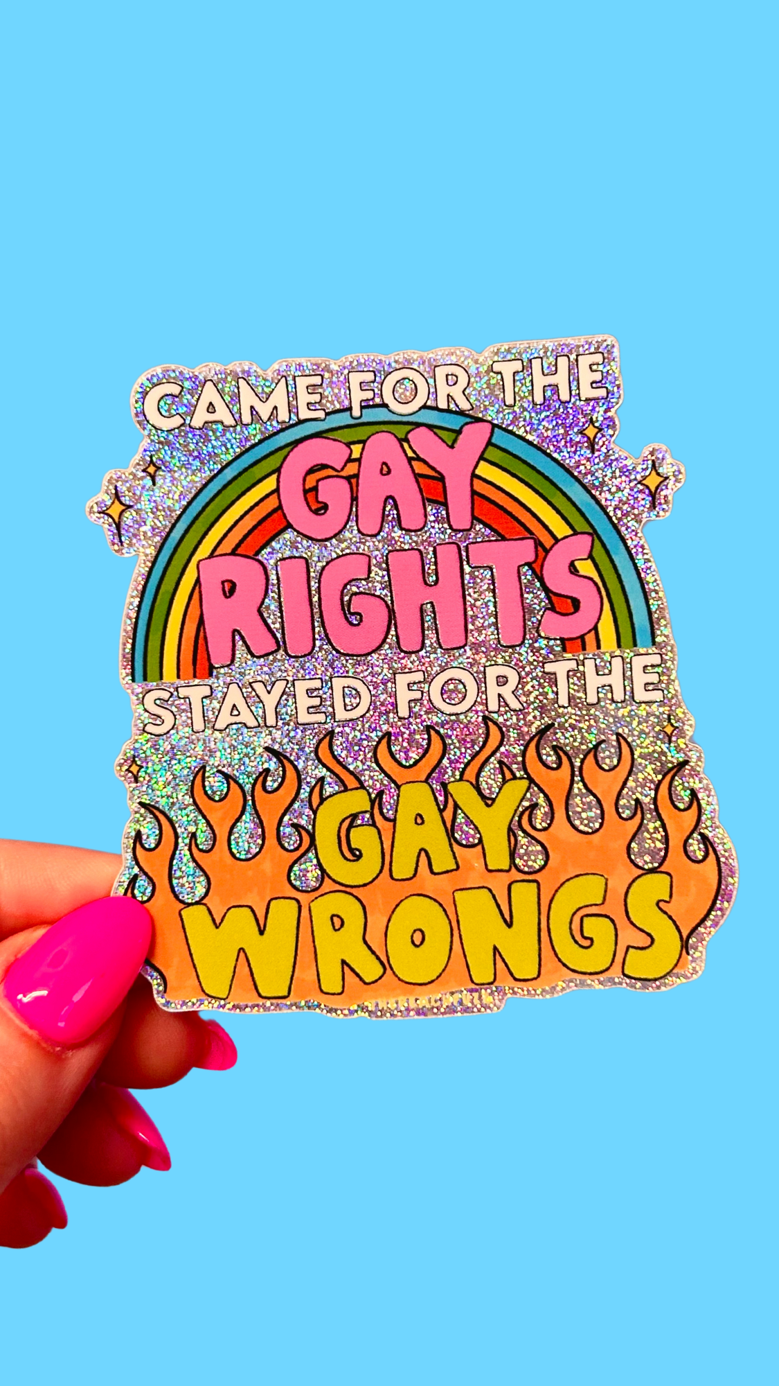 A hand holding a sticker with text and colorful decorative elements on a blue background.