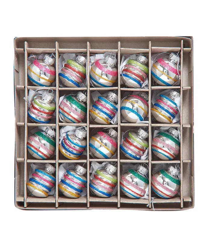 Box of multicolored striped Christmas ornaments on a white background