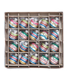 Box of multicolored striped Christmas ornaments on a white background