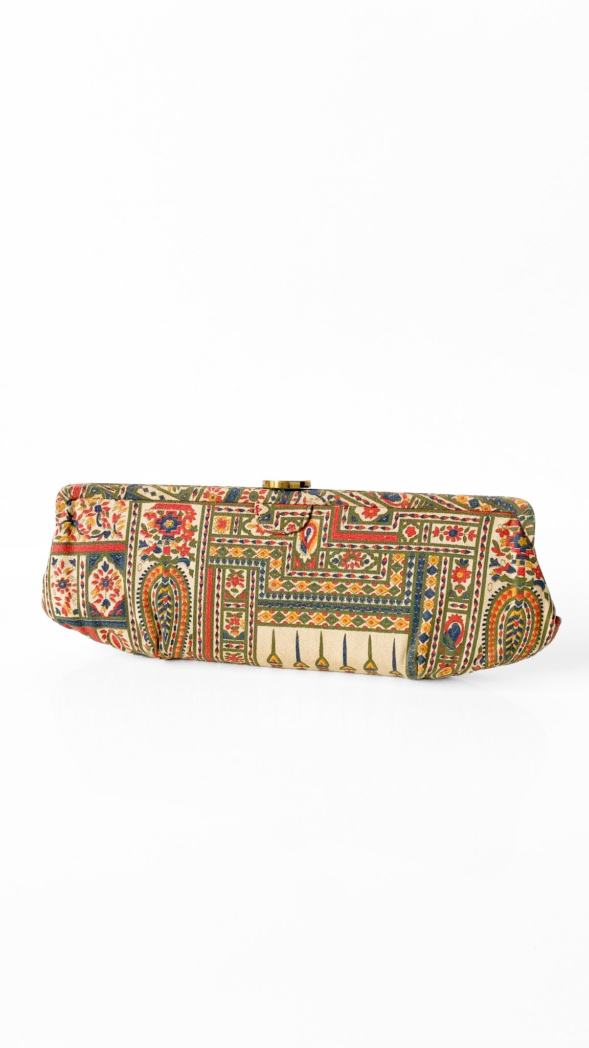 A rectangular clutch bag with an intricate multicolor patchwork pattern featuring red, green, blue, and beige motifs, set against a plain white background.