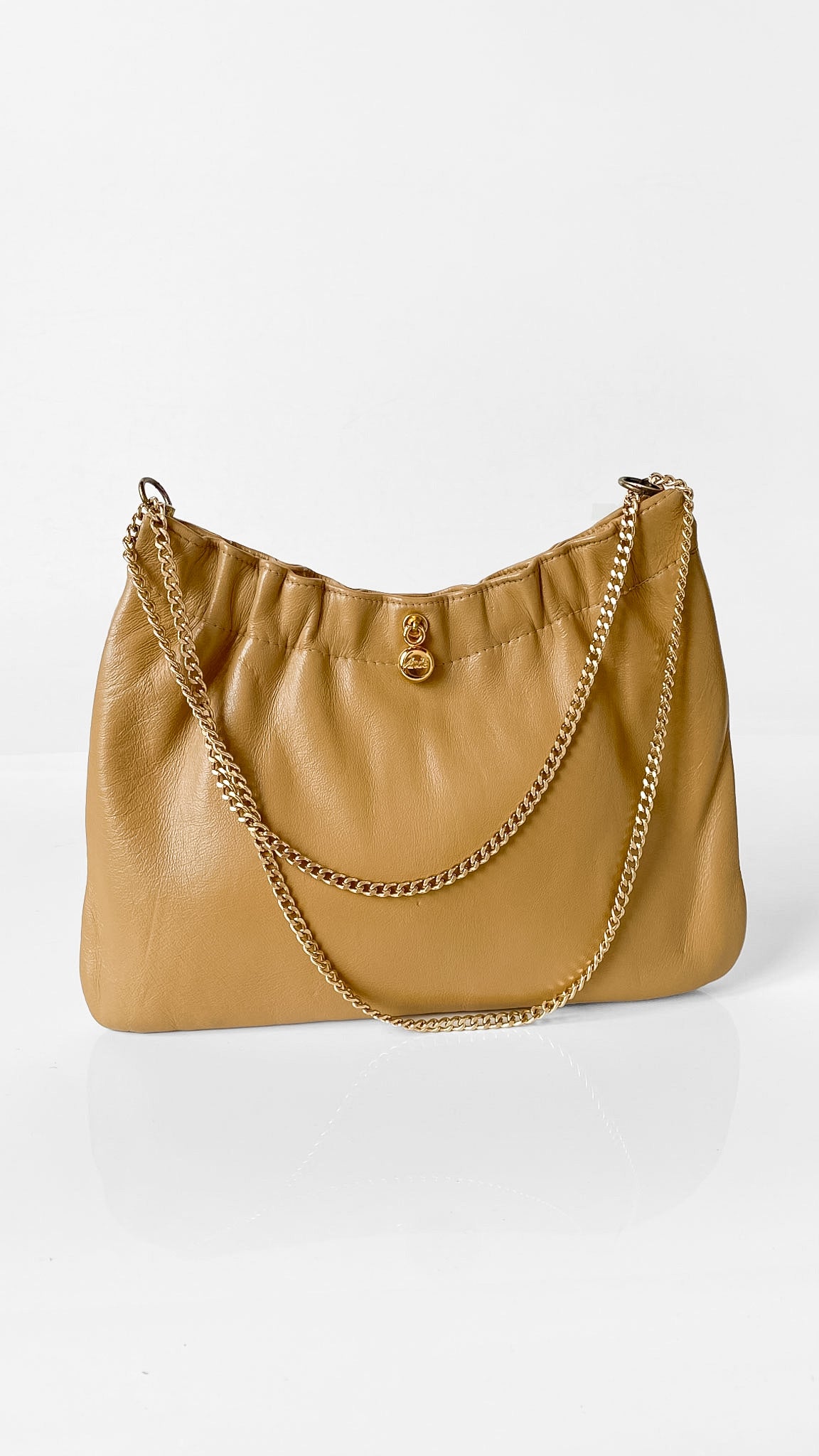 A tan leather shoulder bag with a gold-tone chain strap and a small gold clasp, photographed on a clean white background.