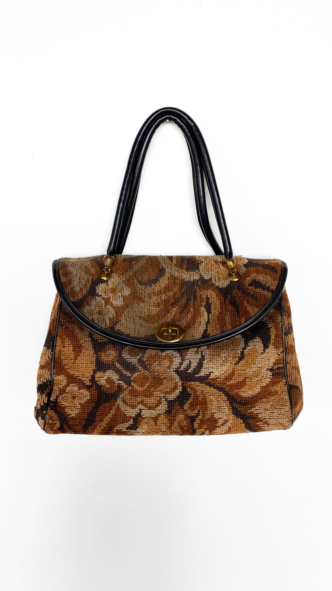 Floral patterned handbag with black handle on a white background