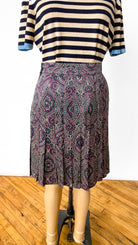 Striped shirt and patterned skirt on a mannequin against a white background