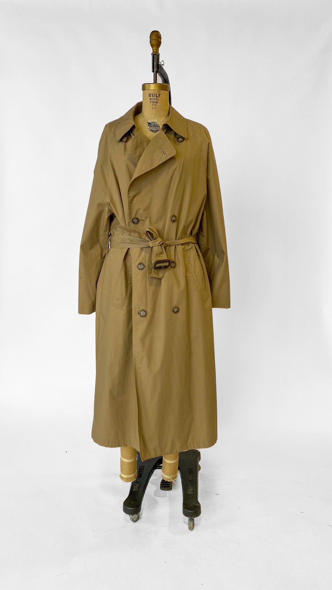 Tan trench coat on a mannequin against a white background
