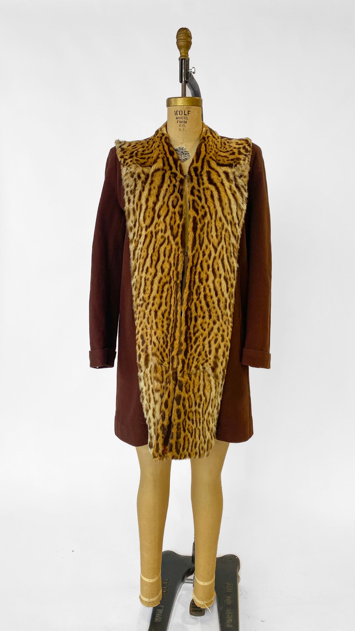 Mannequin wearing a brown coat with a leopard print vest on a white background