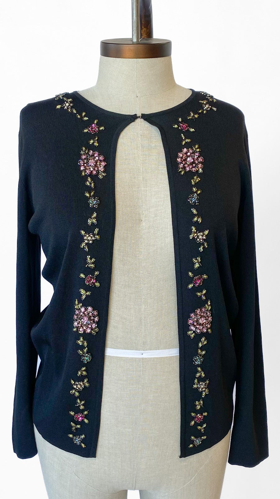 Black cardigan with floral embroidery on a mannequin against a white background