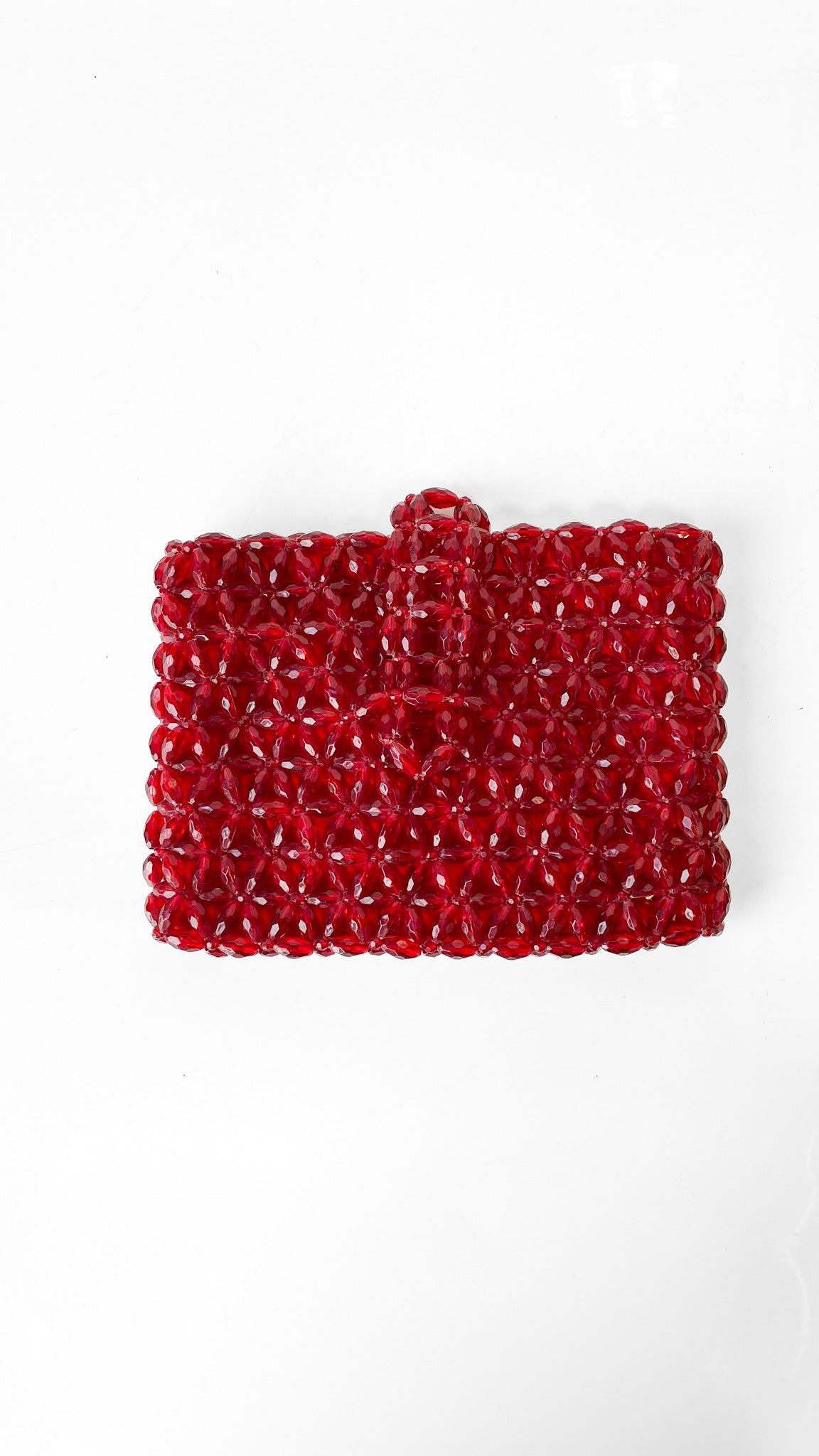 Red beaded clutch bag on a white background