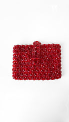 Red beaded clutch bag on a white background