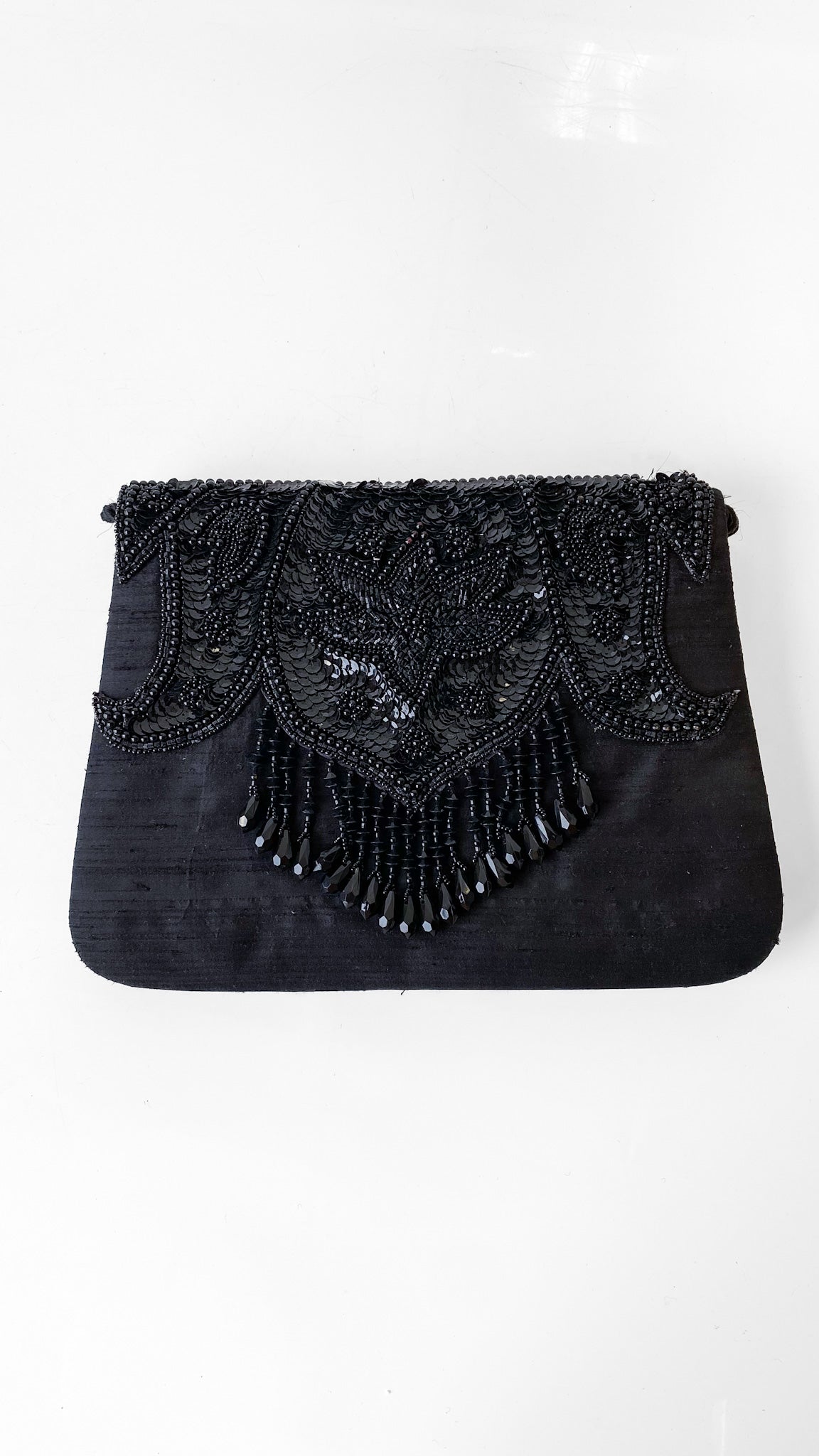 Black beaded clutch bag on a white background