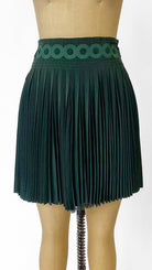 Green pleated skirt on a mannequin against a white background