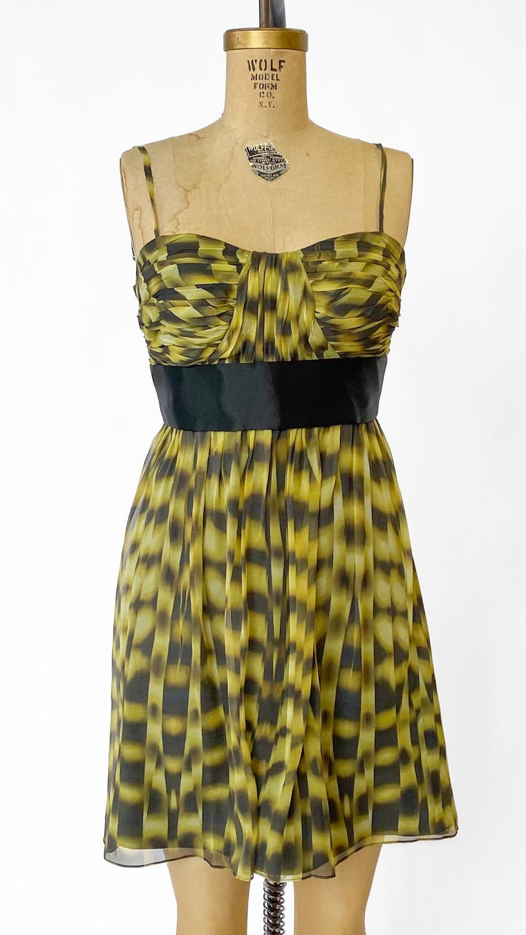 Yellow and black patterned dress on a mannequin against a white background
