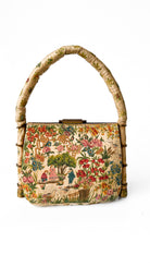 Vintage handbag with floral design and bamboo handle on a white background