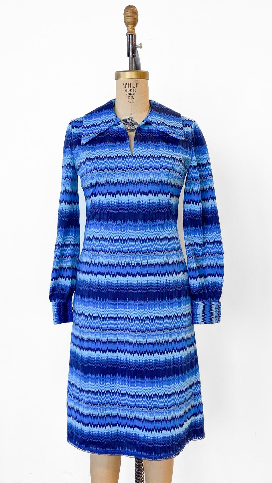 Blue striped coat on a mannequin against a white background