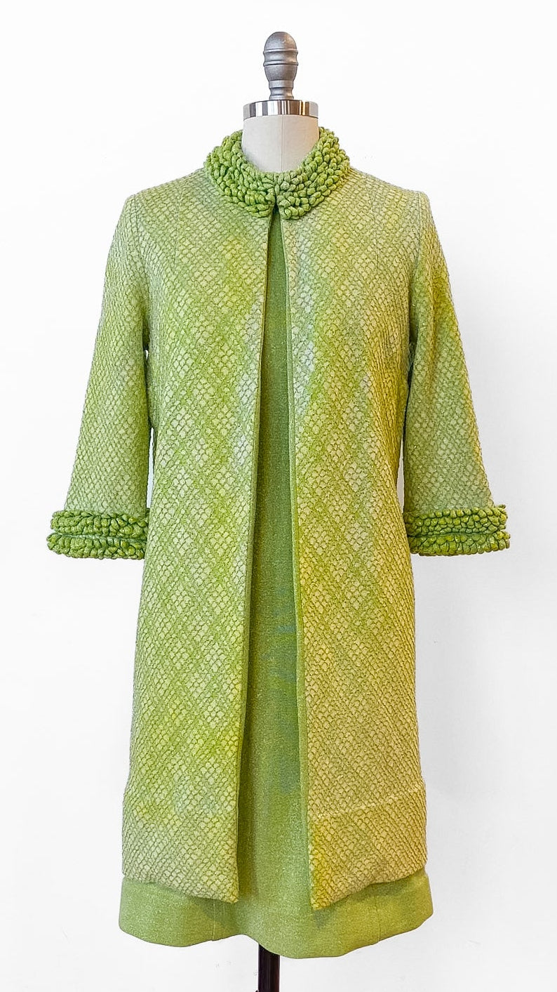 Green textured coat on a mannequin against a white background