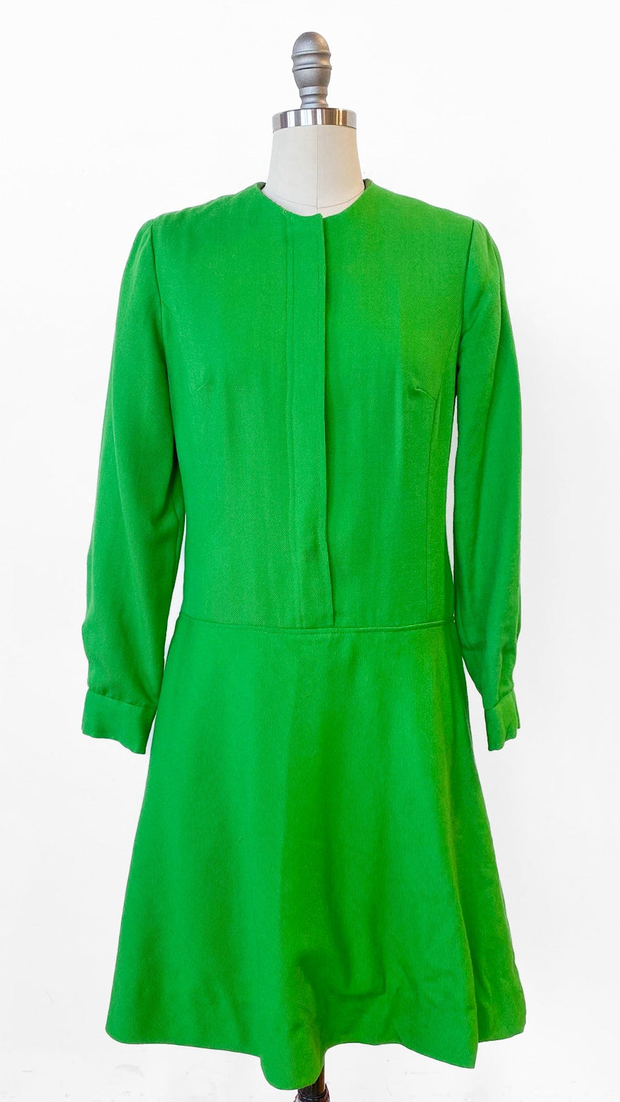 Green dress on a mannequin against a white background