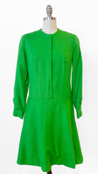Green dress on a mannequin against a white background
