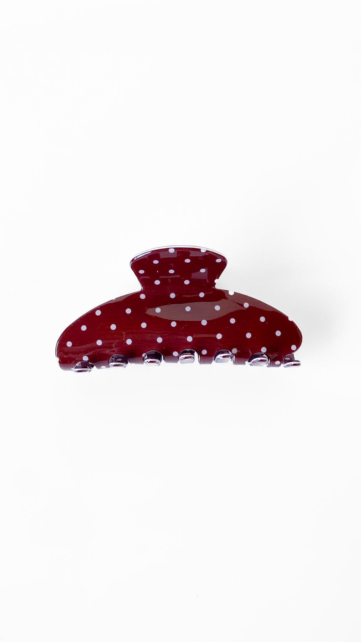 Red polka dot hair clip on a white background