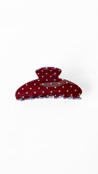 Red polka dot hair clip on a white background