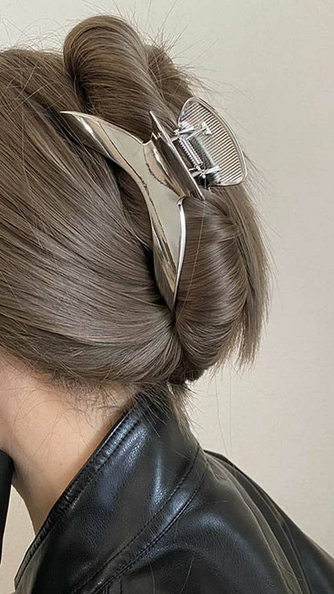 Person with a stylish hair clip in their bun against a neutral background